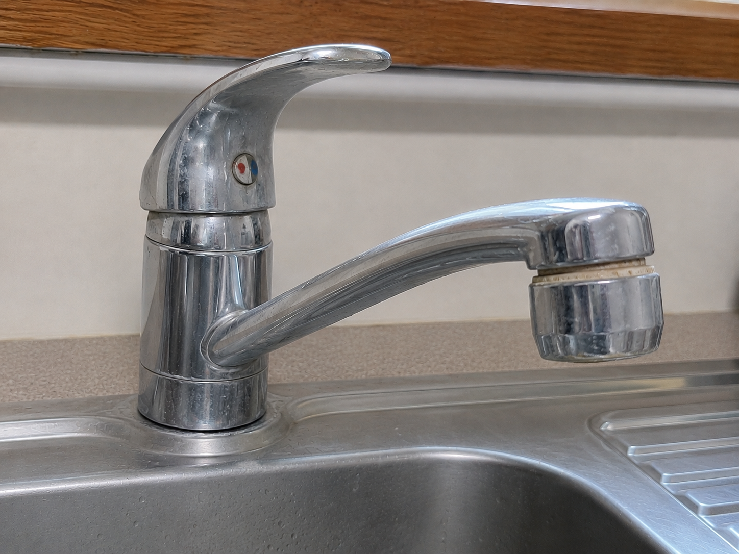 Mineral deposits crusted over a faucet from hard water buildup