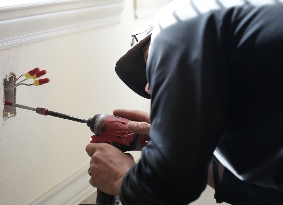 Armstrong electrician working on electrical outlet